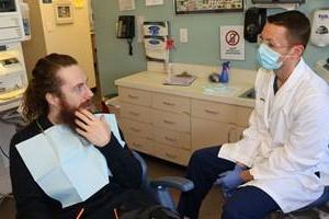 Dentista hablando con paciente en silla