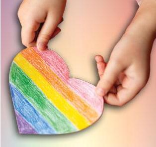 manos de niño sosteniendo corazón arcoiris